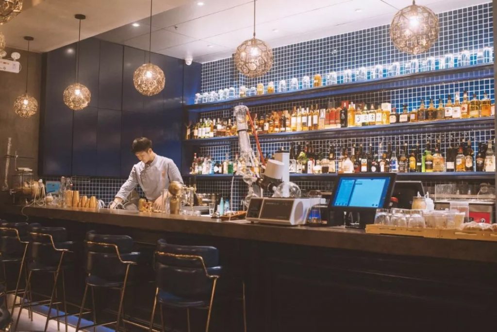 Sit at the bar and order a cocktail.